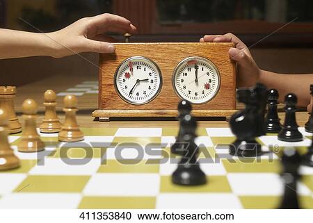 Close-up of chess pieces with a chess clock on a chessboard View Large Photo Image Stock Image - Close-up of chess pieces with a chess clock on a chessboard. Fotosearch