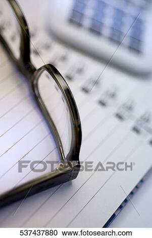 Close-up of eyeglasses on a spiral notebook View Large Photo Image Stock Image - Close-up of eyeglasses on a spiral notebook. Fotosearch