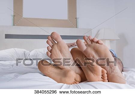 Close-up of feet of a couple on the bed View Large Photo Image Stock Photograph - Close-up of feet of a couple on the bed. Fotosearch