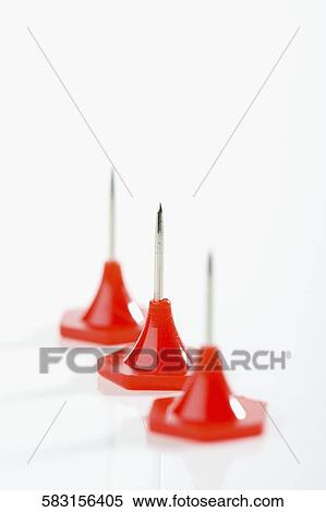 Stock Photography - Close-up of thumbtacks in a row. Fotosearch