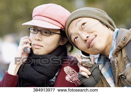 Close-up of two young women listening to mobile phones View Large Photo Image Stock Photo - Close-up of two young women listening to mobile phones. Fotosearch