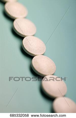 Close-up of white pills in a row View Large Photo Image Stock Photo - Close-up of white pills in a row. Fotosearch