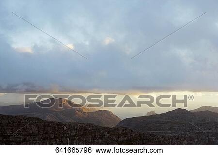 Stock Photograph - Clouds over mountains. Fotosearch