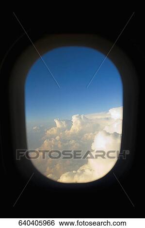 Clouds viewed through a window of an airplane View Large Photo Image Stock Photograph - Clouds viewed through a window of an airplane. Fotosearch