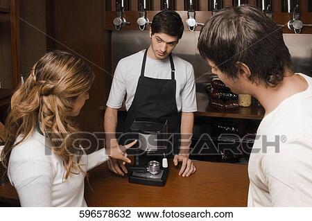 Coffee shop owner showing a coffee maker to customers View Large Photo Image Stock Image - Coffee shop owner showing a coffee maker to customers. Fotosearch