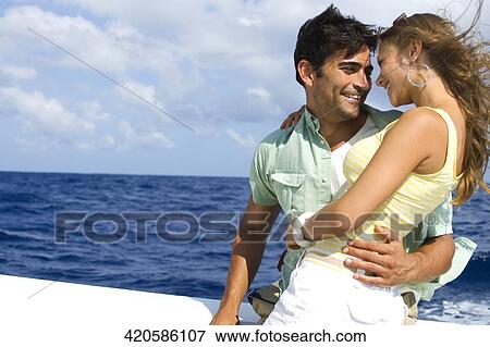 Stock Photo - Couple embracing each other in the boat. Fotosearch