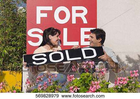 Couple holding an information board and smiling View Large Photo Image Stock Photo - Couple holding an information board and smiling. Fotosearch