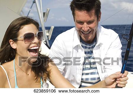 Couple sitting in a boat and fishing View Large Photo Image Stock Photograph - Couple sitting in a boat and fishing. Fotosearch