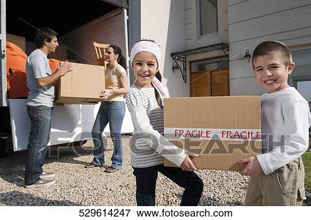 Couple with their children unloading boxes from a pick-up truck View Large Photo Image Stock Photo - Couple with their children unloading boxes from a pick-up truck. Fotosearch