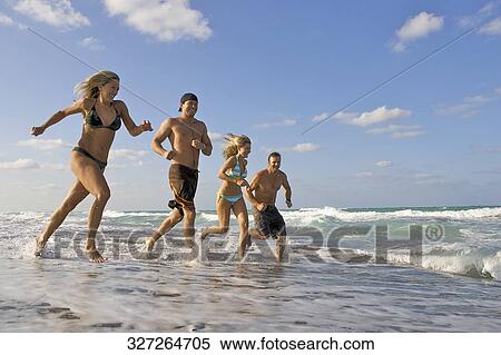 Couples running on the beach View Large Photo Image Stock Photography - Couples running on the beach. Fotosearch