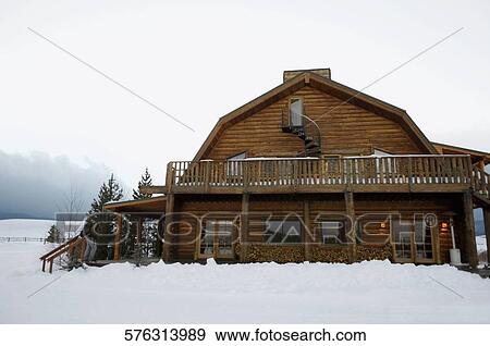 Stock Photo - Facade of a house at a snow covered landscape, West Yellowstone, Gallatin County, Montana, USA. Fotosearch