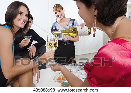 Four friends celebrating with wine and cocktail View Large Photo Image Stock Photo - Four friends celebrating with wine and cocktail. Fotosearch