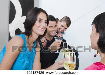 Four friends celebrating with wine and cocktail View Large Photo Image Stock Photograph - Four friends celebrating with wine and cocktail. Fotosearch