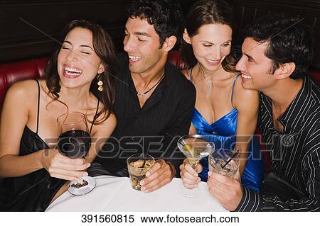 Four friends sitting at a table and smiling View Large Photo Image Stock Photography - Four friends sitting at a table and smiling. Fotosearch