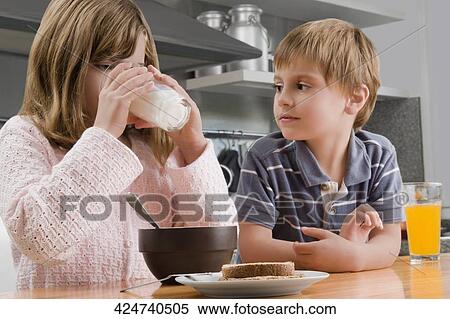 Girl having breakfast beside her brother View Large Photo Image Stock Photography - Girl having breakfast beside her brother. Fotosearch