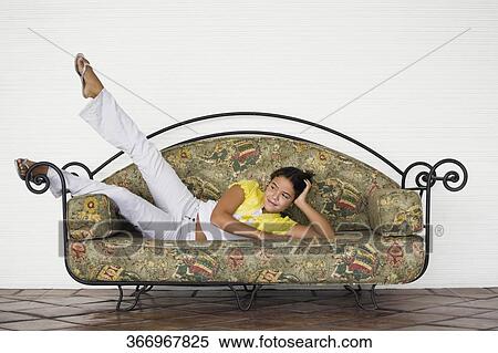 Girl lying on a couch and day dreaming View Large Photo Image Stock Photography - Girl lying on a couch and day dreaming. Fotosearch