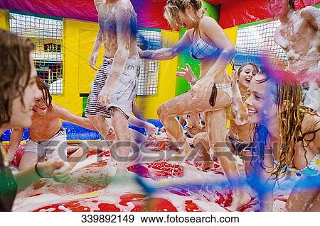 Group of friends enjoying in an inflatable pool View Large Photo Image Stock Photo - Group of friends enjoying in an inflatable pool. Fotosearch