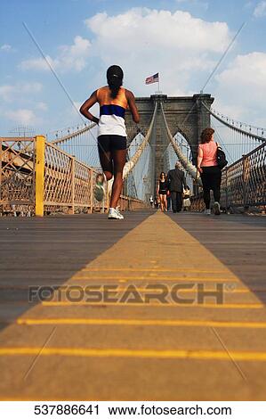 Group of people walking on a bridge View Large Photo Image Stock Image - Group of people walking on a bridge. Fotosearch
