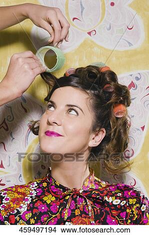 Hairdresser adjusting the hair of a young woman View Large Photo Image Picture - Hairdresser adjusting the hair of a young woman. Fotosearch
