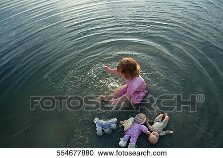 High angle view of a baby girl playing in water View Large Photo Image Stock Image - High angle view of a baby girl playing in water. Fotosearch