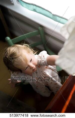 High angle view of a baby girl reaching for a cloth View Large Photo Image Stock Photo - High angle view of a baby girl reaching for a cloth. Fotosearch