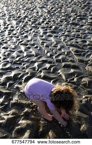 Picture - High angle view of a baby playing with mud. Fotosearch