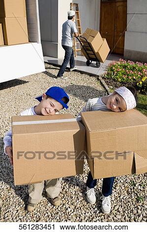 High angle view of a boy and a girl carrying cardboard boxes View Large Photo Image Stock Image - High angle view of a boy and a girl carrying cardboard boxes. Fotosearch