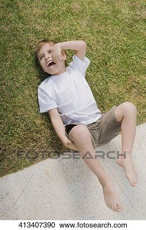 High angle view of a boy lying in a lawn View Large Photo Image Stock Image - High angle view of a boy lying in a lawn. Fotosearch