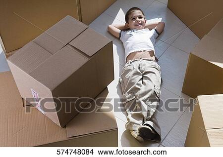 High angle view of a boy lying on the floor and smiling View Large Photo Image Picture - High angle view of a boy lying on the floor and smiling. Fotosearch