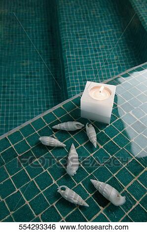 High angle view of a burning candle and sea shells at the poolside View Large Photo Image Stock Photograph - High angle view of a burning candle and sea shells at the poolside. Fotosearch