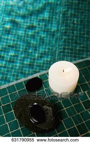 High angle view of a burning candle and pebbles at the poolside View Large Photo Image Stock Photography - High angle view of a burning candle and pebbles at the poolside. Fotosearch