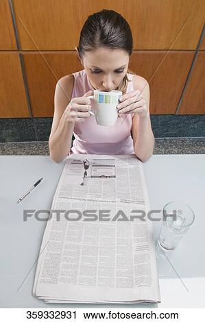 High angle view of a businesswoman drinking coffee and reading a newspaper View Large Photo Image Stock Image - High angle view of a businesswoman drinking coffee and reading a newspaper. Fotosearch