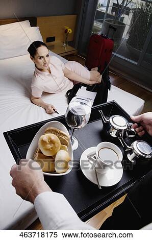 High angle view of a businesswoman lying on the bed and a waiter serving breakfast View Large Photo Image Stock Photography - High angle view of a businesswoman lying on the bed and a waiter serving breakfast. Fotosearch