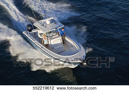 Stock Image - High angle view of a couple on a speedboat. Fotosearch