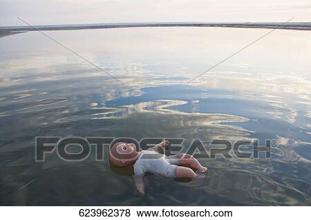 High angle view of a doll floating on water View Large Photo Image Stock Photo - High angle view of a doll floating on water. Fotosearch