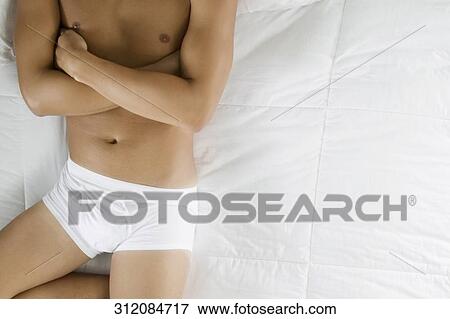 High angle view of a man lying on the bed View Large Photo Image Stock Photo - High angle view of a man lying on the bed. Fotosearch