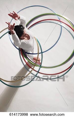 High angle view of a mature woman exercising with hula hoops View Large Photo Image Stock Photo - High angle view of a mature woman exercising with hula hoops. Fotosearch