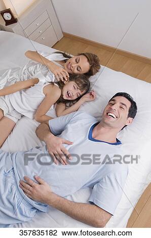 High angle view of a mid adult couple laughing with their daughter View Large Photo Image Stock Image - High angle view of a mid adult couple laughing with their daughter. Fotosearch