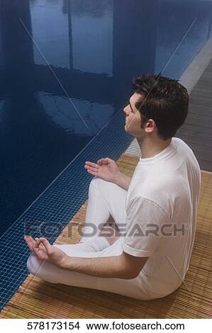 High angle view of a mid adult man practicing yoga at the poolside View Large Photo Image Picture - High angle view of a mid adult man practicing yoga at the poolside. Fotosearch