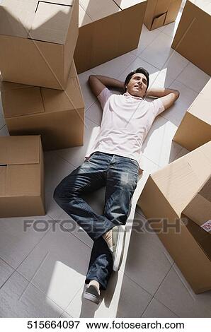 Stock Photo - High angle view of a mid adult man lying on the floor. Fotosearch
