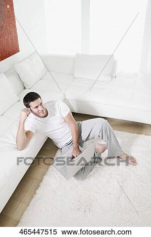 High angle view of a mid adult man holding a credit card and using a laptop View Large Photo Image Stock Photography - High angle view of a mid adult man holding a credit card and using a laptop. Fotosearch
