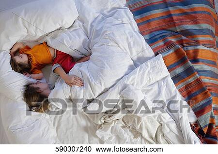 High angle view of a mid adult woman sleeping with her daughter View Large Photo Image Stock Image - High angle view of a mid adult woman sleeping with her daughter. Fotosearch