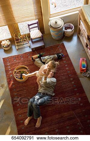 High angle view of a mid adult woman picking up her baby girl View Large Photo Image Stock Image - High angle view of a mid adult woman picking up her baby girl. Fotosearch
