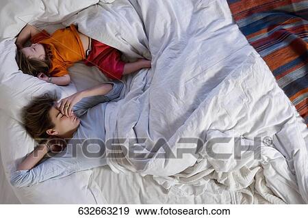 High angle view of a mid adult woman sleeping with her daughter View Large Photo Image Stock Photo - High angle view of a mid adult woman sleeping with her daughter. Fotosearch
