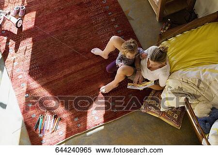 High angle view of a mid adult woman teaching her daughter View Large Photo Image Stock Photography - High angle view of a mid adult woman teaching her daughter. Fotosearch