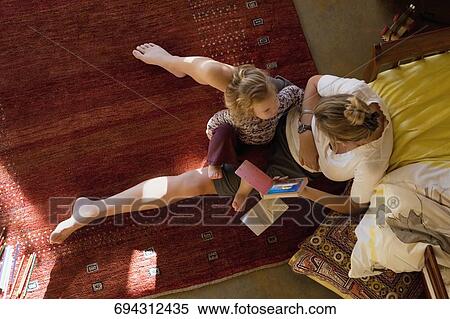 Stock Photography - High angle view of a mid adult woman teaching her daughter. Fotosearch