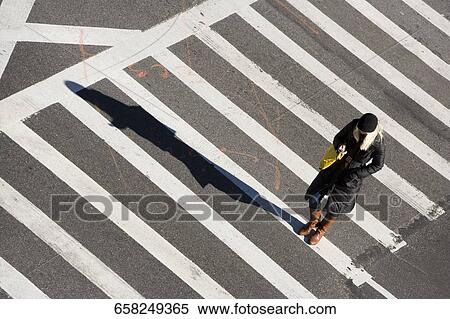High angle view of a woman walking on the crosswalk, Ninth Avenue, New York City, New York state, USA View Large Photo Image Stock Photography - High angle view of a woman walking on the crosswalk, Ninth Avenue, New York City, New York state, USA. Fotosearch