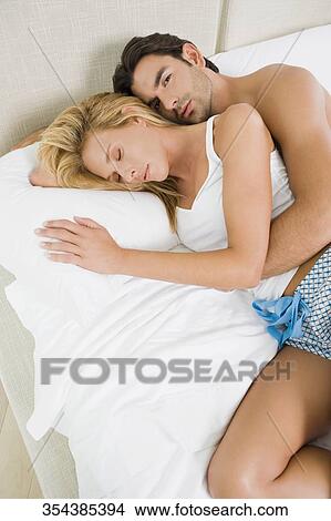 High angle view of a young man and a mid adult woman lying on the bed View Large Photo Image Picture - High angle view of a young man and a mid adult woman lying on the bed. Fotosearch