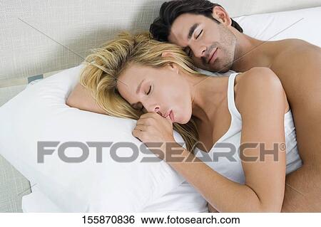 High angle view of a young man and a mid adult woman lying on the bed View Large Photo Image Stock Photograph - High angle view of a young man and a mid adult woman lying on the bed. Fotosearch