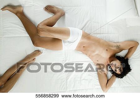 High angle view of a young man lying on the bed View Large Photo Image Stock Photo - High angle view of a young man lying on the bed. Fotosearch
